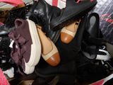 de nombreuses paires de chaussures dans un sac posé par terre