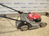 an image of a lawn mower parked in front of a wall