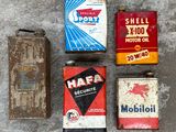several old oil cans are lined up on a cement surface