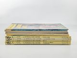 several books stacked on top of each other on a white surface