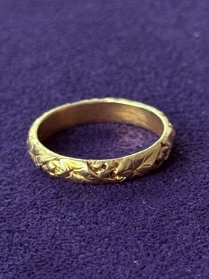 a close up of a gold ring on a purple surface