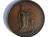 an old bronze medal with a woman and a dog on it