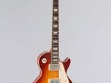 an electric guitar hanging from a string on a white wall
