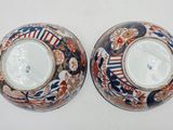 pair of asian vases with floral designs on them on a white surface