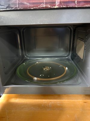un micro-ondes dans lequel se trouve une assiette verte