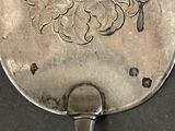 a silver plate with a design on it on a table