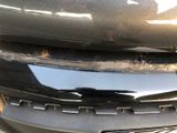 a close up of a car ' s front bumper with a bug on it