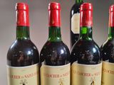 three bottles of red wine are lined up on a table