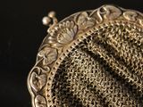 a silver purse that is sitting on a table
