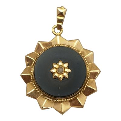 un gros plan d'un pendentif doré et noir sur fond blanc