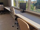 a desk with two chairs and a computer on it