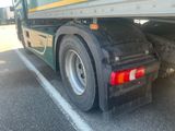 a green and yellow truck parked in a parking lot