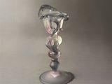 a glass vase with a bird on it on a table
