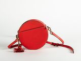 a red round bag with tassels on a white background