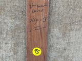 un ski en bois sur lequel est collé un autocollant jaune