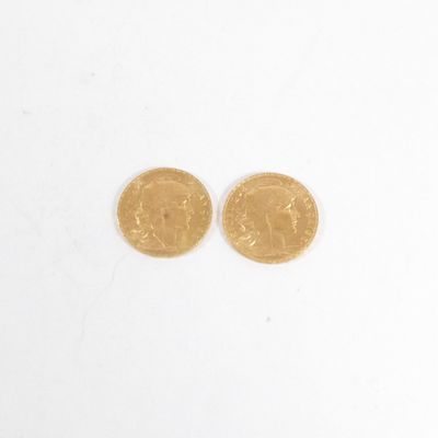 deux pièces d'or posées l'une sur l'autre sur une surface blanche