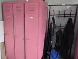 a pink locker in the corner of a room next to a bed