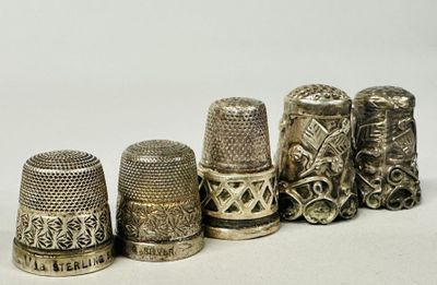 several antique thimbles are lined up in a row on a white surface