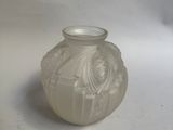 un petit vase blanc posé sur une surface blanche