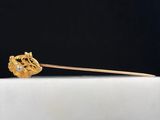 a close up of a gold stick with a flower on it