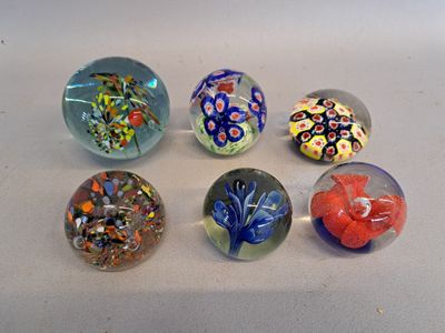 six glass marbles sitting on a white surface
