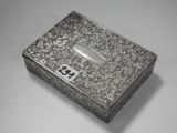 une vieille boîte en argent portant un numéro, posée sur une table