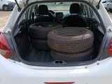 the back of a white car with a bunch of tires in the trunk