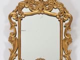 une image d'un miroir encadré d'or sur un mur blanc