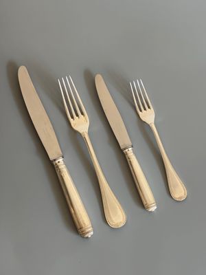 un service composé de quatre fourchettes et d'un couteau posé sur une table
