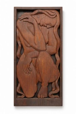 a wooden relief of a woman holding a child in her arms