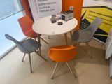 brightly colored chairs and a table in a room with a sign