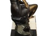 bronze statue of a woman sitting on a marble block with a dog