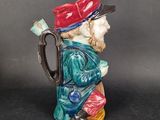 a ceramic figurine of a man with a red hat and a green jacket