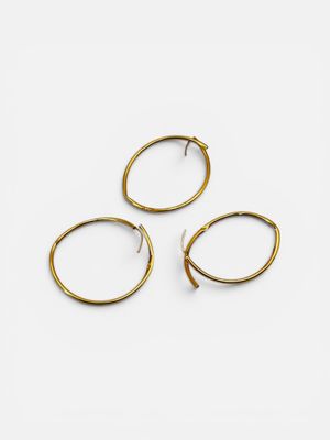 three pairs of gold hoop earrings on a white background