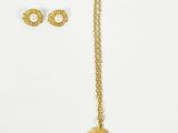 a pair of gold earrings and a necklace on a white background