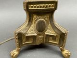 a gold lamp that is on a stand on a table