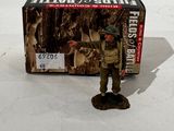 a toy soldier that is standing next to a box