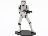 a toy of a stormtrooper with a gun on a white background