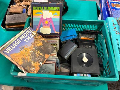 une boîte en plastique verte remplie de livres et de DVD