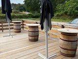 deux parapluies sur une terrasse en bois, avec des tonneaux en bois