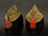 pair of military hats with tassels on top of a mannequin head