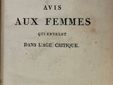 un vieux livre posé sur une table en bois à côté d'une fenêtre