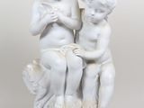 une statue représentant deux enfants assis sur une table
