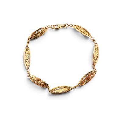un bracelet en or orné de perles ovales sur fond blanc
