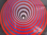 un frisbee rouge et bleu posé sur une surface noire