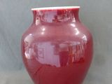 un vase rouge posé sur une table