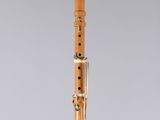 a close up of a wooden clarinet on a clear surface