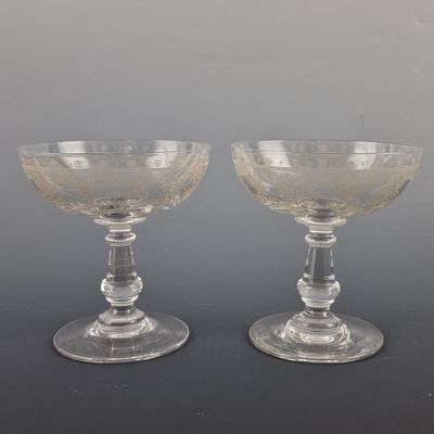 pair of clear glass wine glasses sitting on top of a table