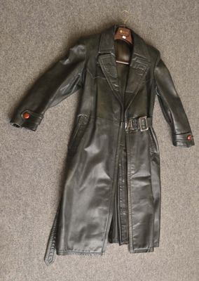 black leather trench coat with red buttons on a hanger