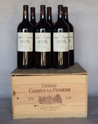 quatre bouteilles de vin dans un coffret en bois posé sur une table